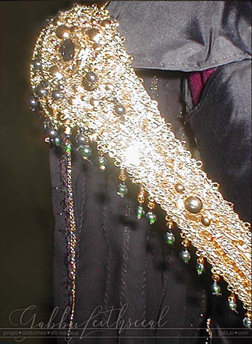 Close up of the gold beaded diagaonal sash on the Dark Lily costume.